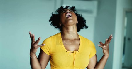 Foto de Una joven mujer negra frustrada gritando desesperada en el cielo haciendo gestos con las manos cuerpo sintiéndose angustiada y sobrepoblada por problemas, persona de 20 años queriendo rendirse - Imagen libre de derechos