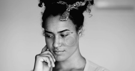 Joven mujer afroamericana monocroma primer plano de alegre latina negra con idea, dedo apuntando hacia arriba en blanco y negro