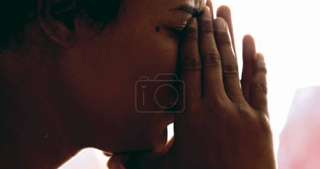 Young woman suffering from depression covers face feeling upset and regretful. Profile close-up of person feeling stress and pressure