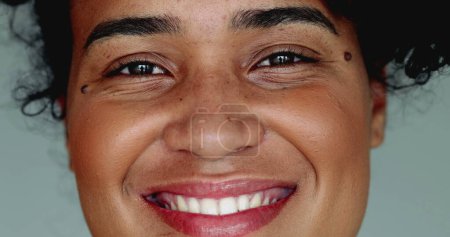 Una joven brasileña negra feliz de ascendencia africana sonriendo a la cámara en un apretado macro primer plano detalle facial sonrisa con comportamiento amistoso