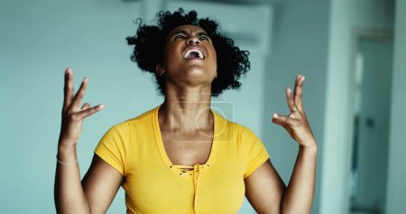Foto de Una joven mujer negra frustrada gritando desesperada en el cielo haciendo gestos con las manos cuerpo sintiéndose angustiada y sobrepoblada por problemas, persona de 20 años queriendo rendirse - Imagen libre de derechos