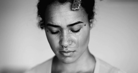 Foto de Una joven mujer negra ansiosa cara de cerca expresando preocupación y desesperación mental en blanco y negro dramático. Desesperada persona de 20 años de ascendencia africana - Imagen libre de derechos