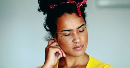 Foto de Joven mujer afroamericana reflexiva que reflexiona sobre la solución al problema de poner la mano en la barbilla en la contemplación mental profunda. primer plano cara de un negro latina adulto 20s chica - Imagen libre de derechos