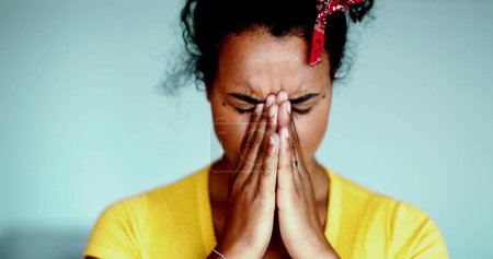 Foto de Bajo presión - Una joven latina negra que cubre la cara se siente abrumada por el arrepentimiento y la ansiedad, luchando con enfermedades mentales. Mujer veinteañera persona de ascendencia africana sufrimiento - Imagen libre de derechos