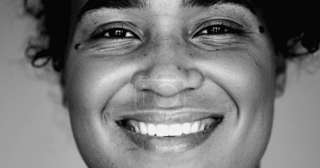 Photo for Monochrome portrait of a joyful black woman macro close-up face expressing happiness. One latina Female 20s person of African descent, black and white - Royalty Free Image