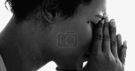 Foto de Intensa joven afroamericana en enfermedad mental lucha dramática monocromática, tranquila desesperación de la niña de 20 años cubriendo la cara que sufre de depresión - Imagen libre de derechos
