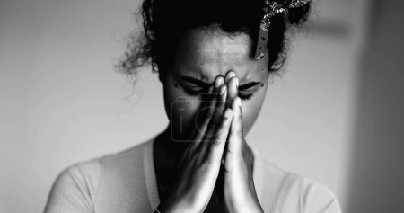 Photo for One Overwhelmed Young Black Latina Covering Face with Regret and Anxiety  Struggling with Mental Illness, Suffering 20s African Descent in dramatic black and white, monochrome - Royalty Free Image