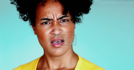 Foto de Una joven negra conmocionada reaccionando a noticias sorprendentes, mirando fijamente a la cámara con la boca abierta, emoción perpleja en los años 20 Dama, primer plano de la persona brasileña - Imagen libre de derechos