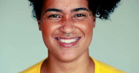 Foto de Una joven y feliz mujer afroamericana de cerca sonriendo y riendo, auténtica expresión de la vida real de una persona brasileña reaccionando al comentario divertido - Imagen libre de derechos