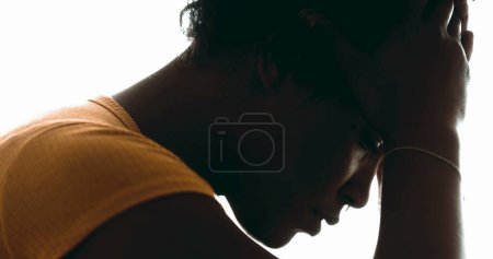 Photo for Candid Lonely Young Woman Struggling with Depression  Pensive Profile Close-Up of Person Holding Head in Hand, Suffering Emotional Pain in dramatic silhouette - Royalty Free Image