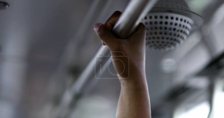Photo for Close-up hand holding metal bar inside public transportation - Royalty Free Image