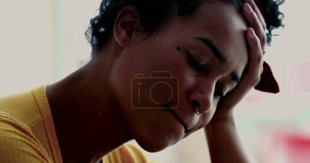 Foto de Una joven franca y solitaria lucha con la depresión, con la cara cercana de una persona pensativa sosteniendo la cabeza y con la mano sufriendo de dolor emocional - Imagen libre de derechos