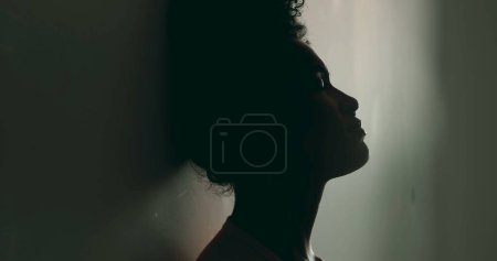 Téléchargez les photos : Une jeune femme noire désespérée, penchée contre le mur dans la solitude, Combattre la maladie mentale, Silhouette d'Afro-Américaine dans la vingtaine souffrant dans la solitude - en image libre de droit