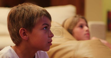 Foto de Reacción de expresión infantil frente a la pantalla de televisión por la noche. - Imagen libre de derechos