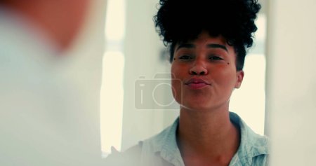 Téléchargez les photos : Une jeune femme noire joyeuse se regardant dans le miroir avec confiance et envoyant un baiser à elle-même prêt à sortir - en image libre de droit
