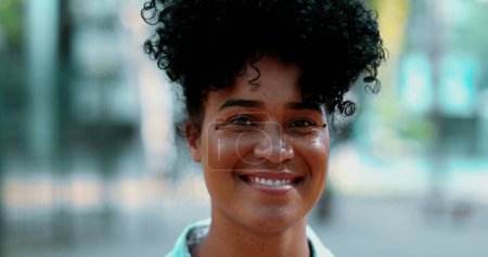 Foto de Una joven brasileña negra feliz sonriendo a la cámara, rastreando la cara de primer plano de una mujer sudamericana de 20 años con cabello rizado de ascendencia africana con expresión amistosa - Imagen libre de derechos