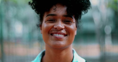 Photo for Close-up of one young black latina woman smiling at camera in tracking shot. Friendly expression of 20s person of African descent portrait - Royalty Free Image