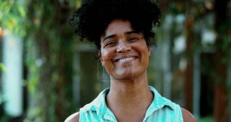 Fröhliche junge schwarze Frau, die mit freundlicher Demeanor, einer südamerikanischen Latina afrikanischer Abstammung, auf die Kamera zugeht