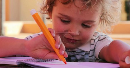 Téléchargez les photos : Little boy holding color pen drawing - en image libre de droit