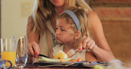 Photo for Mother and little girl together in lunch table candid and authentic - Royalty Free Image