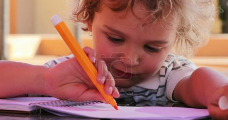 Téléchargez les photos : Little boy holding color pen drawing - en image libre de droit