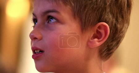 Téléchargez les photos : Réaction réelle de l'enfant regardant l'écran du film - en image libre de droit