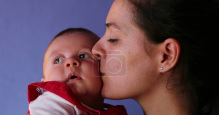 Photo for Mother kissing baby giving love care and affection to infant - Royalty Free Image