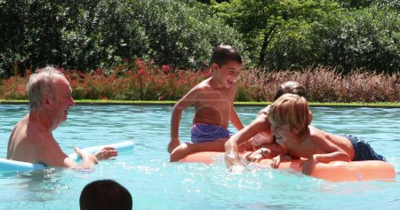 Foto de Niños felices jugando en la piscina en la parte superior de los niños inflables del colchón que se divierten sonriendo y riendo - Imagen libre de derechos