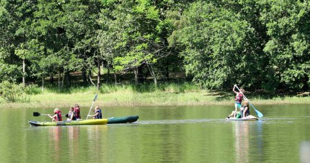 Téléchargez les photos : Enfants kayak dehors au lac à l'intérieur canoë - en image libre de droit