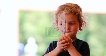 Photo for Little boy playing with knife mother removes dangerous knife from hand - Royalty Free Image