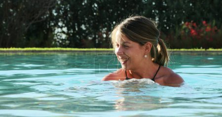 Lässige Frau im Schwimmbadwasser genießt Urlaub
