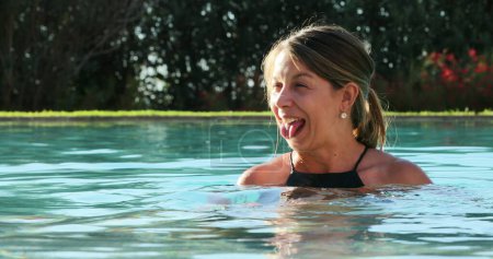 Femme franche décontractée à l'eau de la piscine profitant de vacances