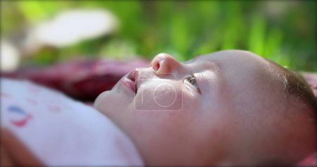 Foto de Newborn baby infant lying on grass outdoors in dreamy day - Imagen libre de derechos