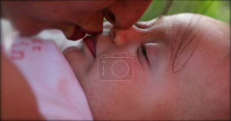 Photo for Mother kissing newborn baby infant outdoors - Royalty Free Image