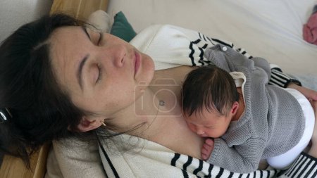 Müde Mutter und Neugeborenes, die während der ersten Lebenswoche des Säuglings schlafen, müde Eltern, die in den ersten Lebenstagen eines Menschen Energie tanken, Mittagsschlaf