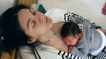 Müdigkeitserholungsschlaf - Müde Mutter und Baby schlafen in den ersten Tagen eines neuen Lebens