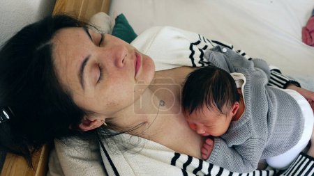 Müdigkeitserholungsschlaf - Müde Mutter und Baby schlafen in den ersten Tagen eines neuen Lebens