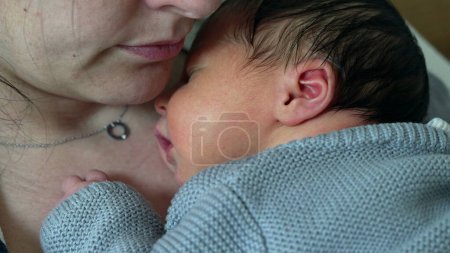 Newborn baby resting on mother's chest during first week of life, infant's initial days of life asleep resting