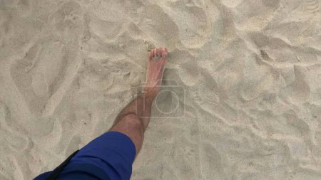 Person POV legs walking at the beach, feeling the sand