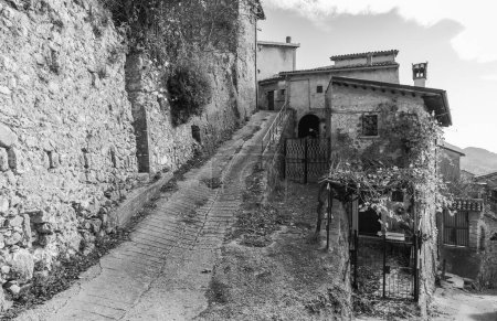 Photo for Steep uphill road in black and white along the ancient walls of the ancient village of Petrella Salto in the province of Rieti. Italy. - Royalty Free Image