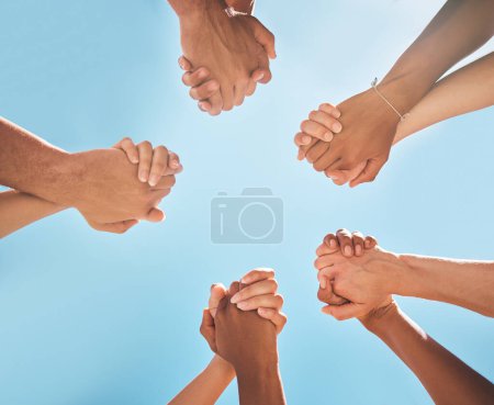 Téléchargez les photos : Les mains, la solidarité et la prise de main, le soutien et la collaboration, le partenariat et la diversité avec fond bleu ciel. Travail d'équipe, unité et groupe de personnes, esprit d'équipe et communauté en toute confiance - en image libre de droit