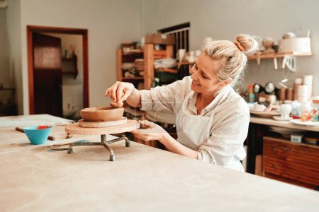 J'adore la poterie et tout ça. une femme façonnant un pot d'argile dans son atelier