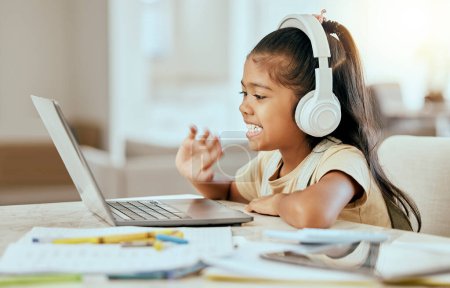 Photo for Video call, online education and child with laptop, headphones and home table for e learning virtual class. Hello, zoom call and girl kid in elearning school listening to audio kindergarten language. - Royalty Free Image