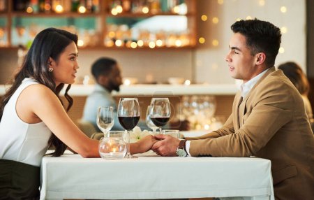 Photo for Romantic dates are their thing. an affectionate young couple holding hands while sitting at a table in a restaurant - Royalty Free Image