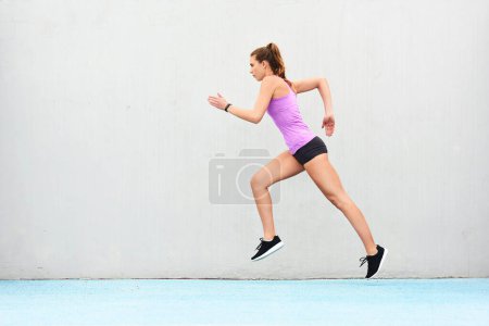 Photo for Shes in great shape for the race ahead. Full length shot of an attractive young female athlete running along the track - Royalty Free Image