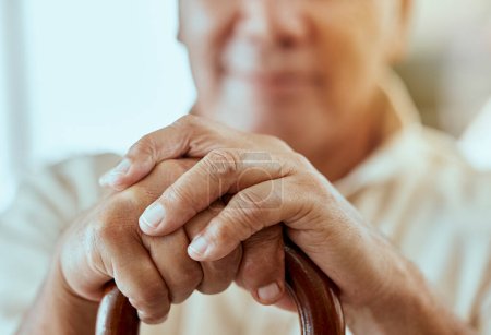 Homme âgé, les mains et la canne pour l'invalidité, l'arthrite ou l'ostéoporose à la maison. Gros plan, retraite et handicap homme âgé tenant un bâton de marche en bois pour le soutien, le vieillissement ou l'aide et l'assistance