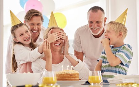 Photo for Surprise, mother birthday and family celebrate at a party at home with a happy smile. Mama, father and children with happiness and excited joy in a house with event food, cake and candles for mom. - Royalty Free Image