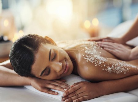 Photo for The place where your troubles simple melt away. a young woman getting an exfoliating massage at a spa - Royalty Free Image