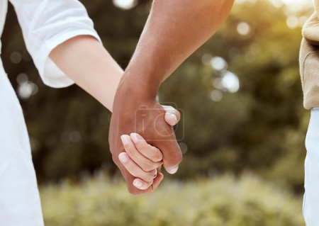Photo for Diversity, holding hands and couple being romantic, support and being together for relationship, marriage and unity. Multiracial, hand gesture and interracial for romance, outdoor holiday and union - Royalty Free Image