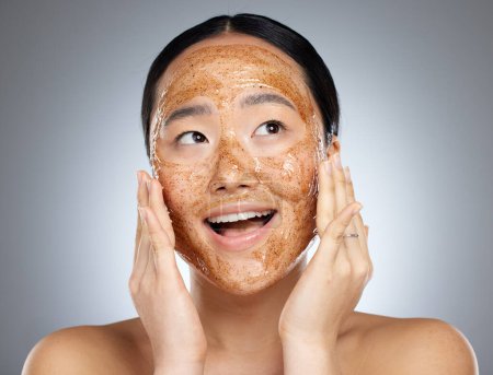 Téléchargez les photos : Masque visage femme, exfoliant et asiatique pour une peau saine, lisse et douce et heureuse du résultat cosmétique. Modèle beauté avec produit de nettoyage du visage avec sourire et bien-être pour prévenir l'acné sèche. - en image libre de droit